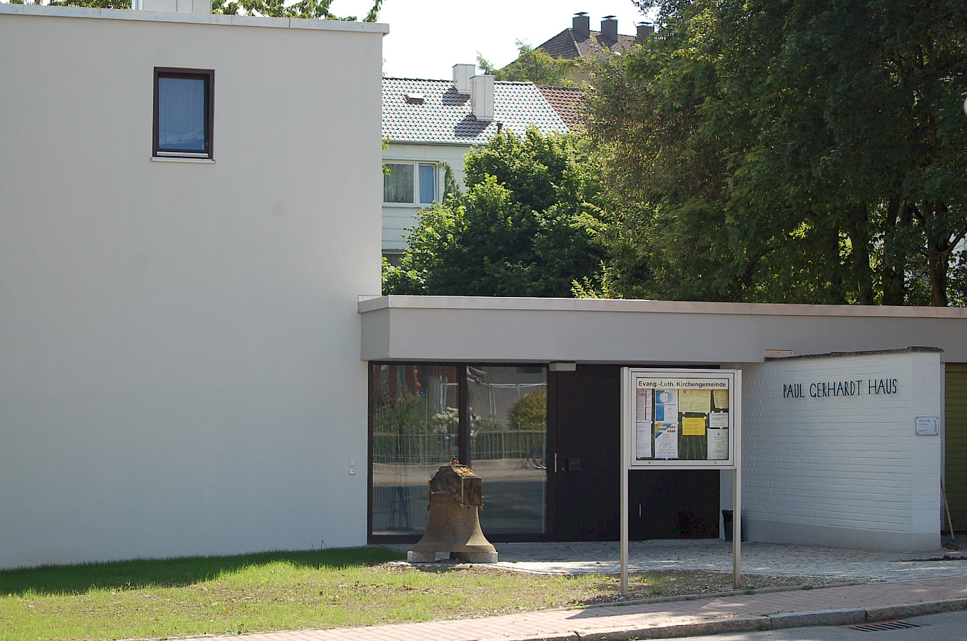 Paul-Gerhardt-Haus Freising — Eingangsbereich mit Schaukasten und historischer Glocke